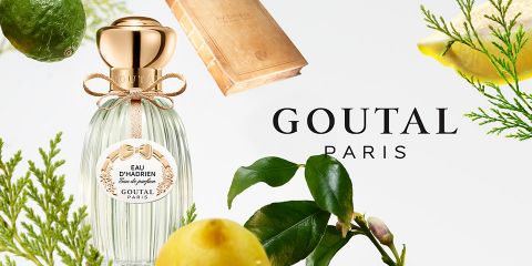 Il flacone di profumo Eau d'Hadrien di Goutal Paris è circondato da agrumi e foglie verdi che risaltano su uno sfondo chiaro. Il logo di Goutal Paris è ben visibile accanto al flacone.