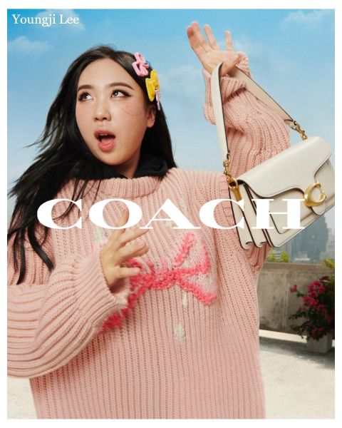Una persona tiene una borsa bianca e indossa un maglione rosa e un accessorio per capelli. Sullo sfondo si vedono un cielo blu e un paesaggio di tetti. Il testo sull'immagine recita "Youngji Lee" e "Coach".
