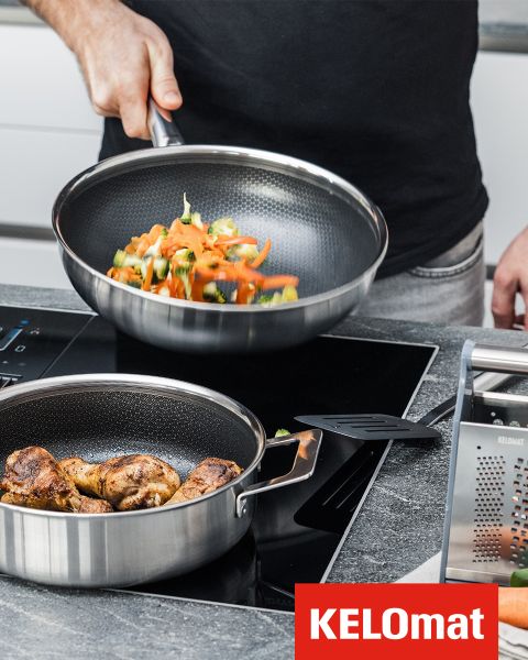 Una persona frigge delle verdure in una padella su un fornello, mentre nelle vicinanze si trova un'altra padella con del pollo cotto. Nell'angolo è visibile il logo KELOmat.