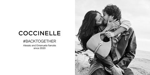 Una foto in bianco e nero mostra una coppia che sorride e si abbraccia su una spiaggia rocciosa. L'uomo tiene una borsa. Il testo a sinistra recita: "Coccinelle #BACKTOGETHER Alessio ed Emanuela sono fidanzati dal 2020".