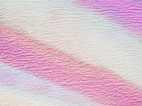 Immagine astratta con linee morbide e ondulate nei toni del rosa, del viola e del bianco. La texture ricorda una superficie increspata, creando un motivo rilassante e stratificato.