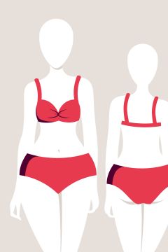 Immagine di due manichini che indossano costumi da bagno rossi in due pezzi. La figura a sinistra indossa un modello con top attorcigliato, mentre la figura a destra ha un design più semplice con top dritto. Entrambe indossano slip da bagno coordinati su uno sfondo beige.