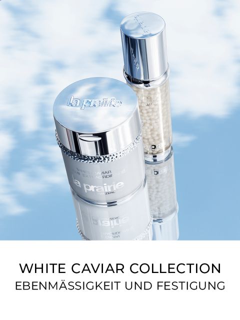 Due prodotti per la cura della pelle della collezione White Caviar di La Prairie sono presentati su uno sfondo di cielo azzurro nuvoloso. Il testo sottostante recita: "Collezione White Caviar: Uniformità e rassodamento".