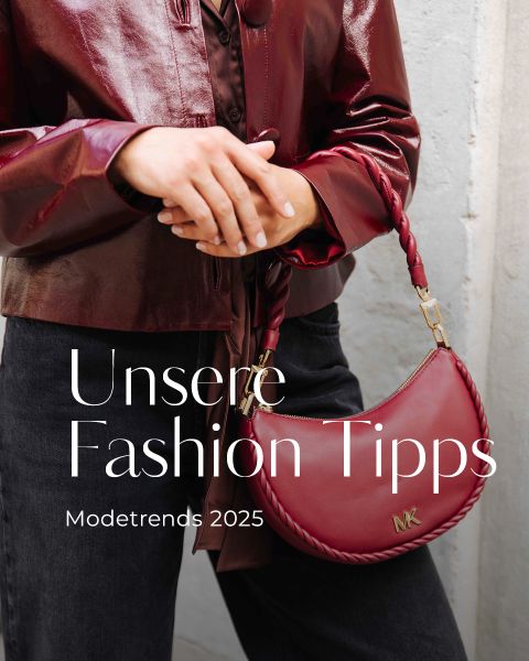Una persona con una giacca di pelle bordeaux lucida tiene in mano una borsetta MK abbinata. Il testo sull'immagine recita: "I nostri consigli di moda. Tendenze moda 2025."