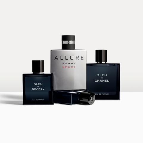 Tre flaconi di profumo sono esposti. Al centro, un grande flacone di "Allure Homme Sport" di Chanel, affiancato da due flaconi di "Bleu de Chanel". I flaconi sono disposti con stile su uno sfondo neutro.