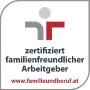 Logo con un simbolo stilizzato con elementi grigi e rossi. Il testo recita "datore di lavoro certificato a misura di famiglia", in fondo si trova il sito web "www.famigliaundberuf.at".
