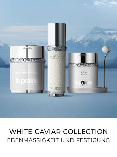 Esposizione di tre prodotti per la cura della pelle La Prairie della collezione White Caviar sullo sfondo di un paesaggio montano con un lago. In basso si legge il testo in tedesco "UNIFORMITÀ E RASSODAMENTO".