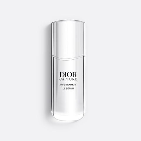 Una bottiglia sottile e traslucida di Dior Capture OX-C Treatment Le Sérum. La bottiglia è alta e sinuosa, con un design minimalista e testo nero sul davanti. Su uno sfondo grigio chiaro.