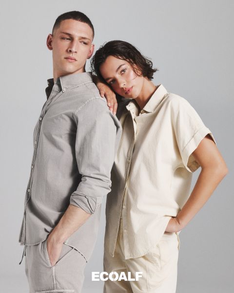 Una persona che indossa un cappotto invernale nero trapuntato è in piedi davanti a uno sfondo semplice e chiaro. La parola "ECOALF" è chiaramente leggibile al centro dell'immagine.