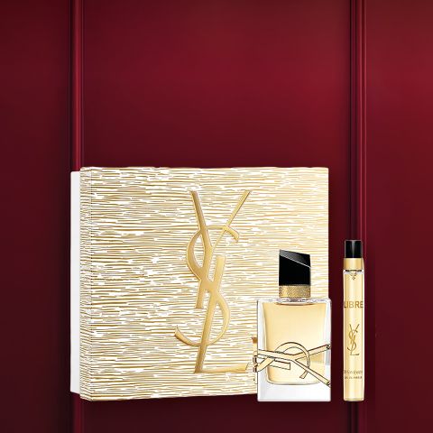 Set regalo profumato in una cornice rosso scuro con una scatola a motivi floreali, un piccolo flacone di profumo e un tubetto bianco con tappo dorato. In alto, in caratteri bianchi, si legge "Set profumo".