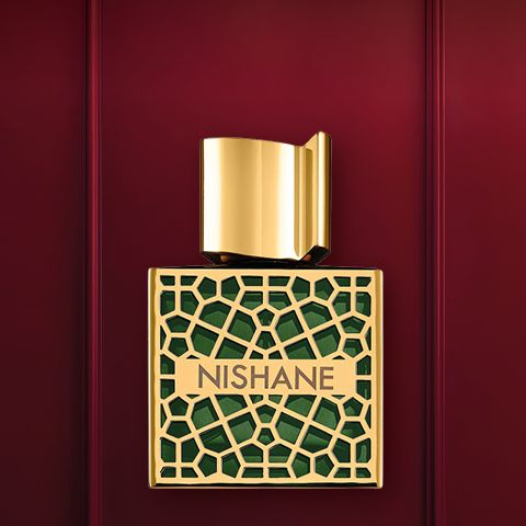 Su uno sfondo rosso intenso, si vede un flacone di profumo di lusso con un design in oro e cristalli. Sotto si trova il tappo del flacone. Sopra, in bianco, si legge la scritta "REGALI DI LUSSO".