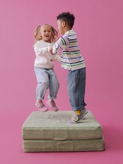 Due paia di scarpe per bambini su sfondo beige: un paio è viola chiaro con cinturini rosa, l'altro è azzurro con cinturini gialli.