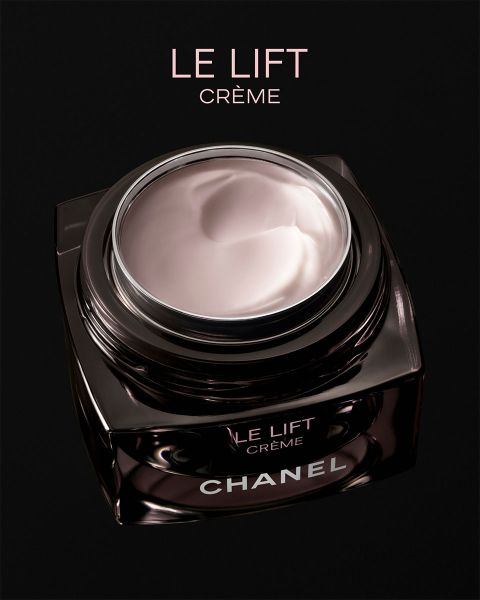 Una donna dalla pelle radiosa posa accanto a due correttori Chanel Les Beiges, indossando gioielli in argento su uno sfondo beige delicato.