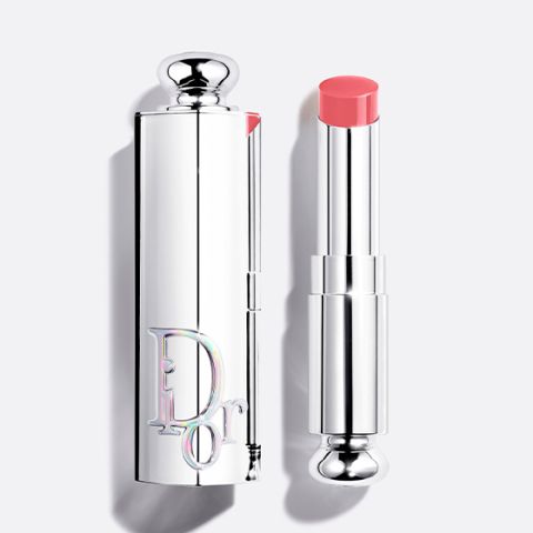 Una bottiglia di fondotinta Dior con tappo nero e la scritta "DIOR" in verticale sulla parte anteriore, fotografata su uno sfondo chiaro.