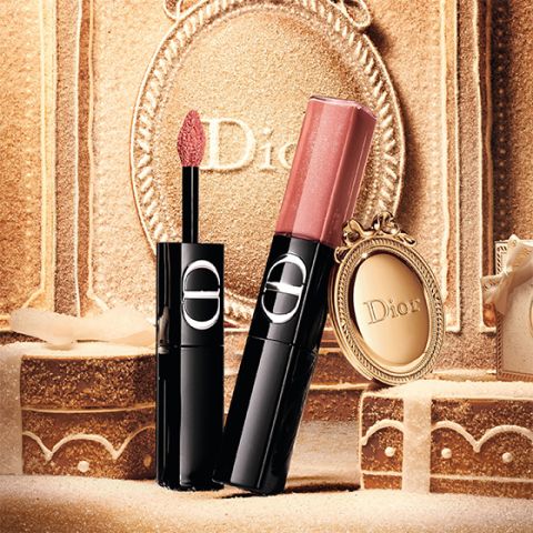 Un rossetto liquido rosso di Dior, con l'applicatore estratto e il tappo argentato accanto, il tutto su sfondo bianco.