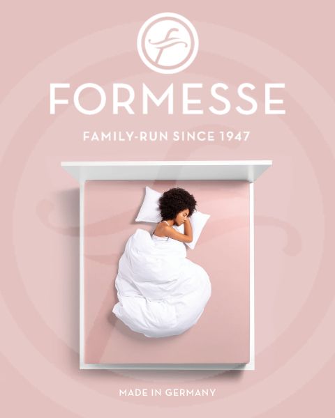 Una donna con i capelli biondi dorme su un fianco su un letto azzurro chiaro. La sua testa riposa su un cuscino bianco. Nella parte inferiore dell'immagine si vedono la scritta "Formesse" e un logo.