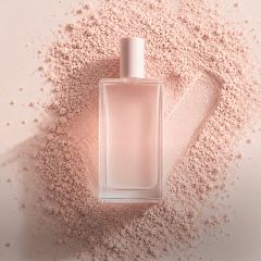 Un flacone di profumo in vetro trasparente con un tappo rosa pallido è appoggiato su della polvere rosa, accanto alla quale è disegnato un segno di spunta nella polvere.