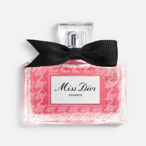 Elegante flacone di profumo dorato con design sinuoso e tappo rotondo trasparente su uno sfondo chiaro con ombre morbide.