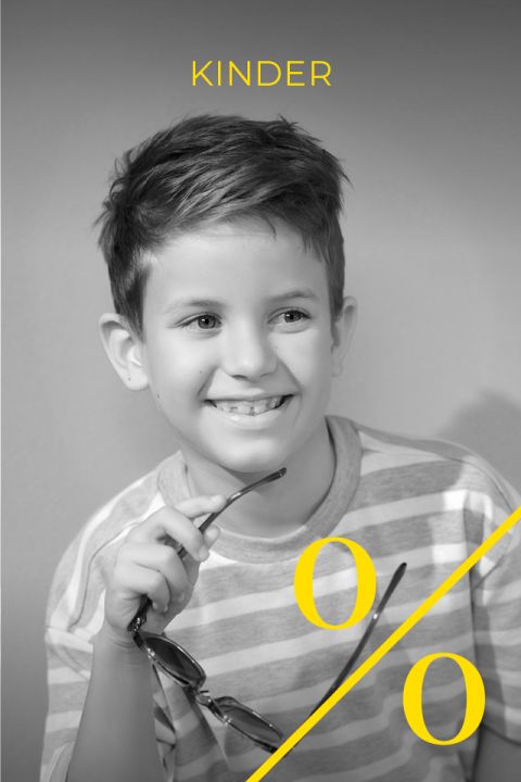 Foto in bianco e nero di un ragazzo sorridente con una camicia a righe e gli occhiali. La parola "BAMBINI" e un simbolo di percentuale giallo sono sovrapposti all'immagine in caratteri gialli.