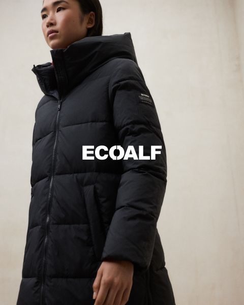 Una persona che indossa un cappotto invernale nero trapuntato è in piedi davanti a uno sfondo semplice e chiaro. La parola "ECOALF" è chiaramente leggibile al centro dell'immagine.
