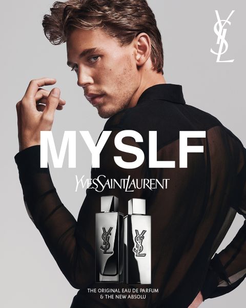 Un uomo in una camicia nera trasparente posa con una mano davanti al viso. Sopra di lui appare il testo "MYSLF" e "Yves Saint Laurent". In basso si vedono due flaconi di profumo YSL con logo e nomi dei prodotti.