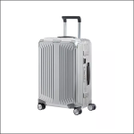 Ein silberner Hartschalenkoffer mit strukturierter Oberfläche, vier Rädern, einem ausziehbaren Griff und einem seitlichen Tragegriff, aufrecht stehend auf weißem Hintergrund dargestellt.