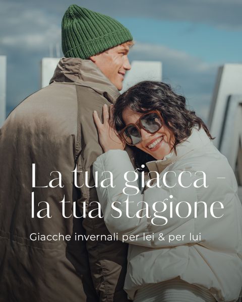 Una donna sorridente con una giacca invernale bianca e occhiali da sole è appoggiata a un uomo con un berretto di lana verde e un cappotto invernale marrone. Il testo in italiano pubblicizza giacche invernali per uomo e donna.