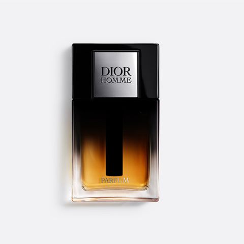 Un flacone di Dior Homme Parfum con un design in vetro con gradiente chiaro-scuro e un tappo nero su uno sfondo bianco semplice.