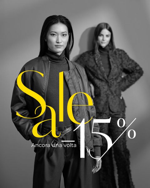 Due donne in eleganti abiti scuri posano per un annuncio di vendita di moda con il testo: "Saldi -15%. Ancora una volta."