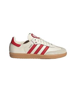 Sneaker bianco con strisce e tallone rossi, suola in gomma marrone chiaro e scritta "SAMBA" sul lato. Classico design Adidas su uno sfondo bianco semplice.