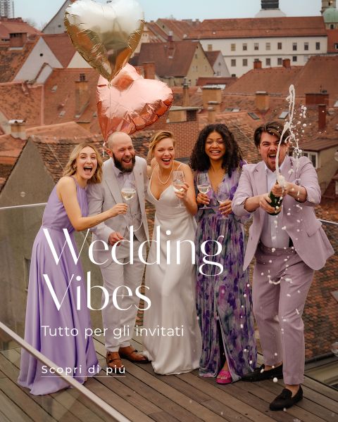 Cinque persone in abiti da festa festeggiano su un tetto con champagne e palloncini a forma di cuore; il testo recita "Wedding Vibes, Tutto per gli invitati, scopri di più.