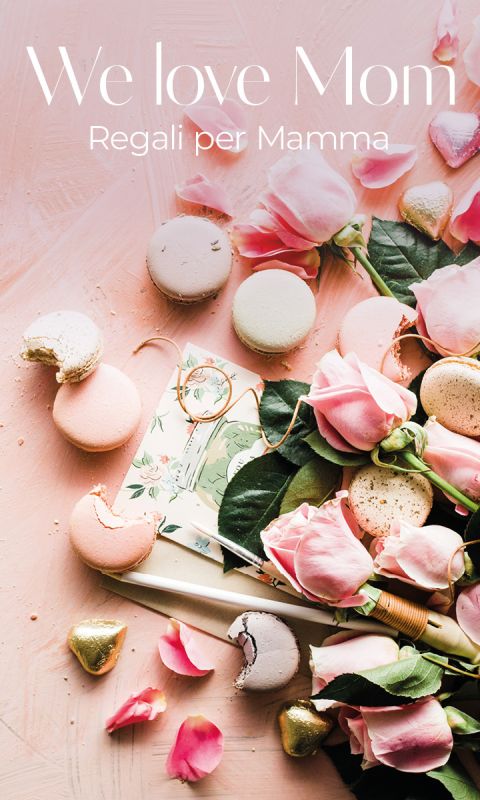 Rose rosa, macarons color pastello, praline incartate in oro e un biglietto floreale su sfondo rosa con il testo "We love Mom. Regali per Mamma.