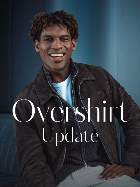 Un uomo sorridente con una sovracamicia marrone e una maglietta bianca è seduto su un divano. Il testo sull'immagine recita: «Overshirt-Update».