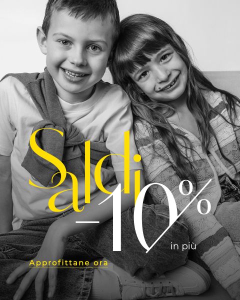 Due bambini sorridenti sono seduti vicini su un divano. Sopra l'immagine è visibile un testo pubblicitario italiano che promette un ulteriore sconto del 10%.