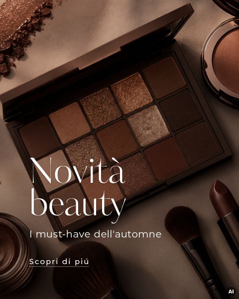 Una palette di ombretti aperta con tonalità marroni, circondata da pennelli e rossetto, con testo italiano che promuove i must-have di bellezza dell'autunno.