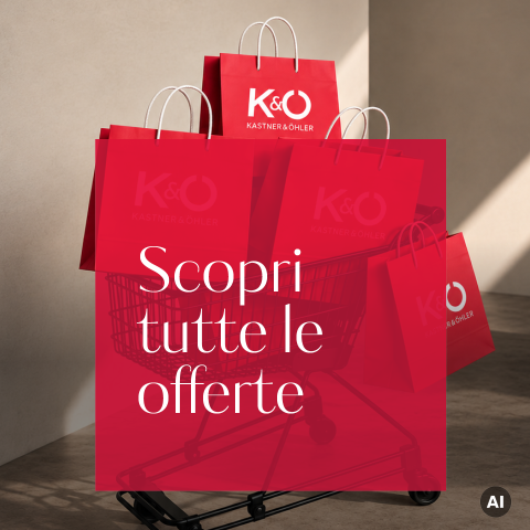 Buste della spesa rosse in un carrello con la scritta "Kastner & Öhler", sopra un testo in italiano: "Scopri tutte le offerte.".