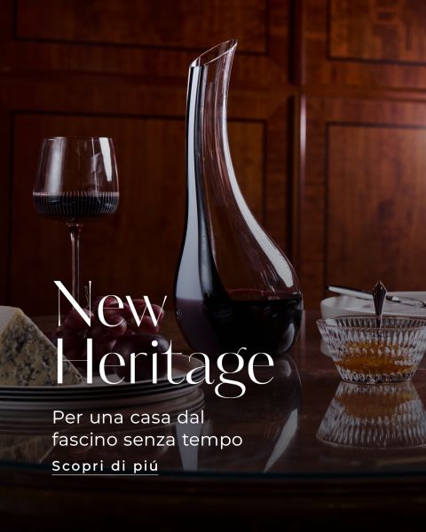 Una caraffa, un bicchiere da vino, formaggio e una ciotola di cristallo su un tavolo di legno, accompagnati da un testo in italiano sull'eleganza senza tempo nell'ambiente domestico.
