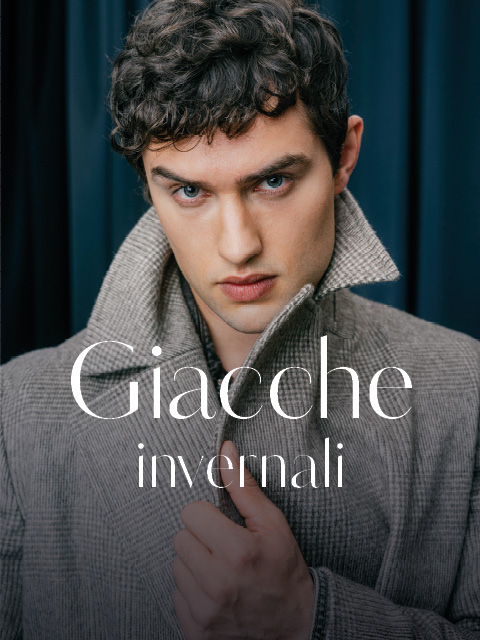 Un uomo che indossa un cappotto a fantasia grigia con colletto rialzato, sopra il quale si legge la scritta "Giacche invernali".