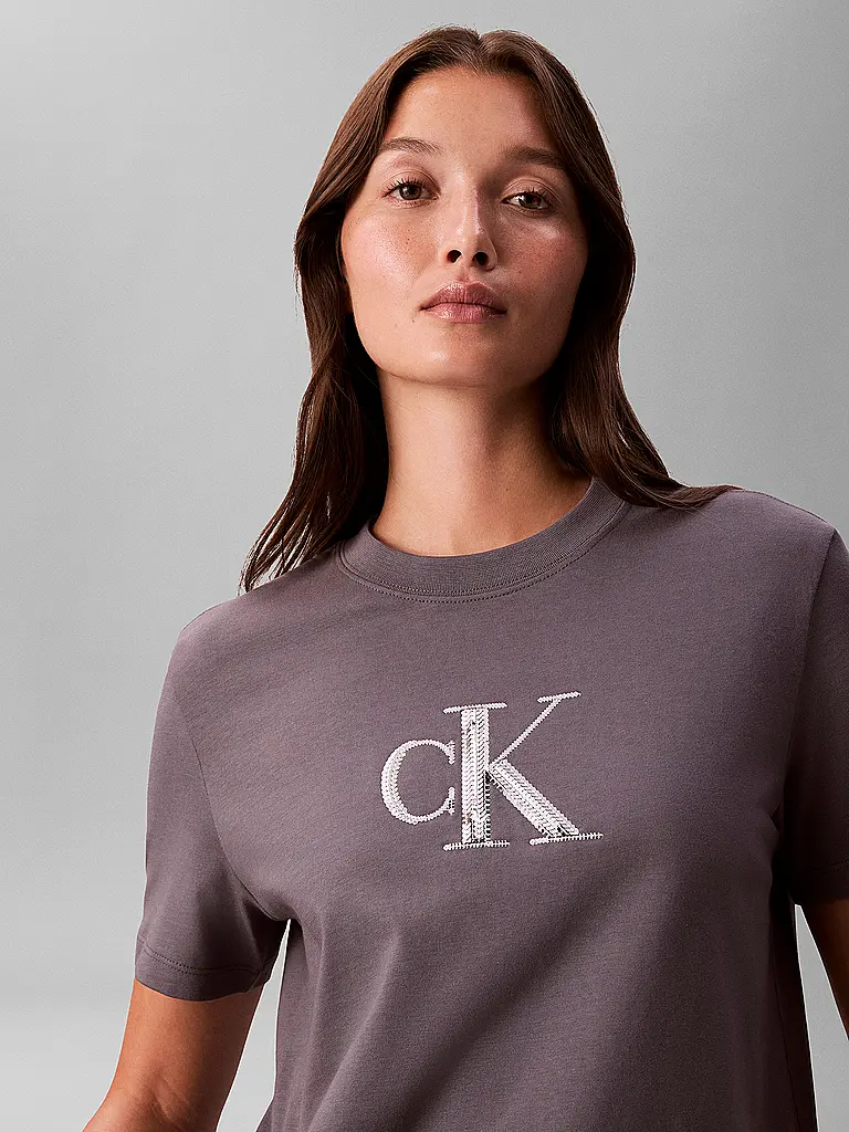 CALVIN KLEIN JEANS | T-Shirt
Marke: CALVIN KLEIN JEANS
Farbe: grau
Kategorien: Mode,Damen

Ärmellänge: Kurzarm
Ausschnitt: Rundhalsausschnitt
Material: Jersey,Baumwolle
Musterung: Logo
Passform (Oberbekleidung): Regular
Stil: Young Fashion
Details: Pailletten | 